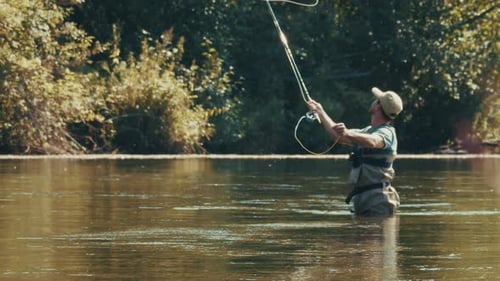Angler Fishing on the River and Casting the Line