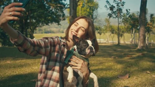 Woman Takes Selfie With Dog in Sunny Park