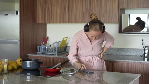 Woman Dancing to Music in the Kitchen
