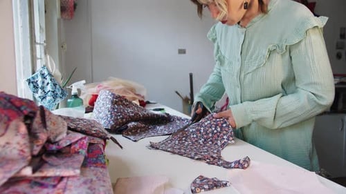 Woman Cutting Floral Fabric for Sewing at Home