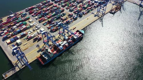 Container ship in export and import business and logistics. Shipping cargo to harbor by crane. Water