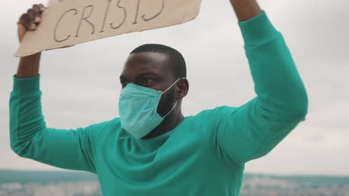 Adult Protests with Sign and Mask Outdoors