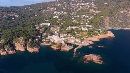 Stunning aerial shot slowly revealing the picturesque coastal village of fornells, featuring its