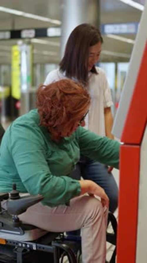 Mujer en silla de ruedas validando el billete con un amigo