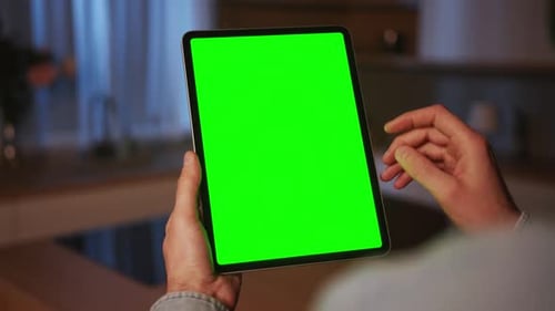 Footage of Caucasian Male Left Hand Holding Digital Tablet with Green Screen Man Touching Screen