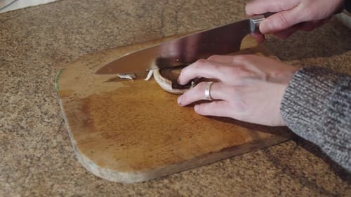 Mushroom Being Sliced on Cutting Board