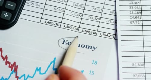 Pencil circles the word "Economy". Concept: economy, finance, crisis, business plan,