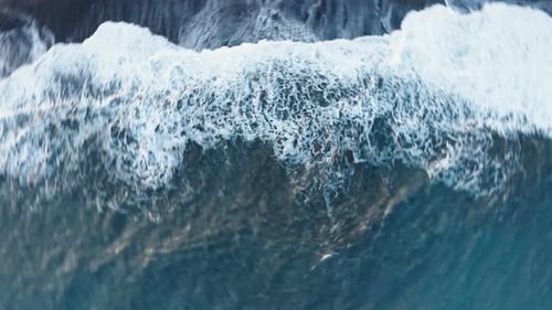Fast Chaotic Spin Vertical on the Stormy Ocean Waves Crashing on the Beach