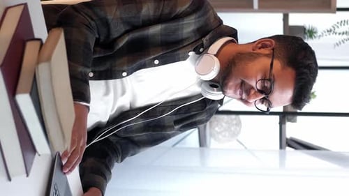 Young Adult Works on Laptop at Home