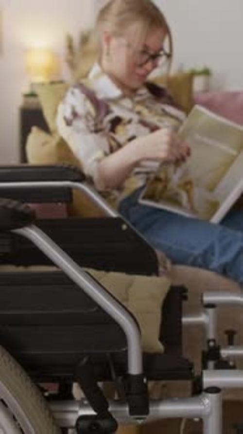 Vertical of Manual Wheelchair and Young Woman Reading Fashion Magazine