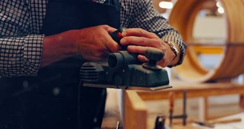 Carpenter Using Wood Planer in Workshop