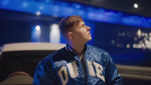 Solitary Person Pauses Beneath Vibrant Neon Bridge Illumination During Night Lone Young Man Standing