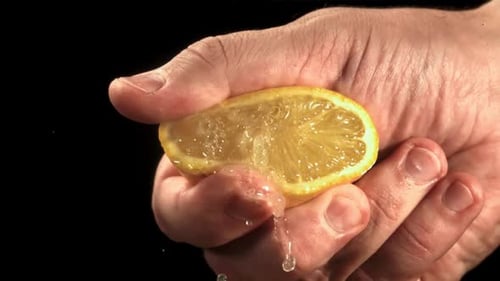 Hand Squeezing Half a Lemon, Draining Juice