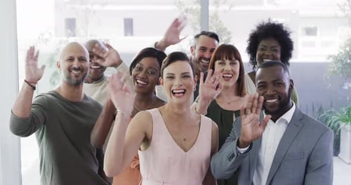 4k video footage of a group of happy businesspeople waving in a modern office