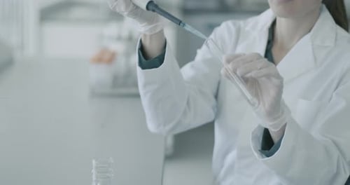 Female Scientist Working with Pipette and Test Tube