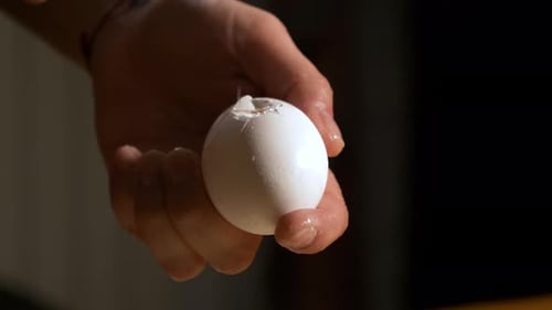 4K close up slow motion shot craked white fresh egg with a silver spoon