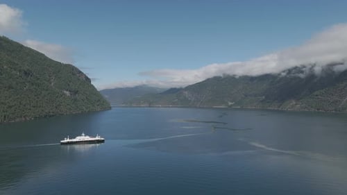 Drone shot of a car Ferry crossing the Fjord in Norway on a sunny day with clear water and reflectio