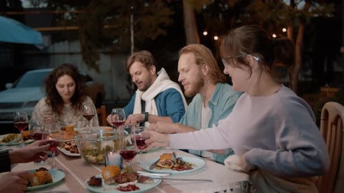 Friends Celebrating Over Dinner Clinking Wine Glasses