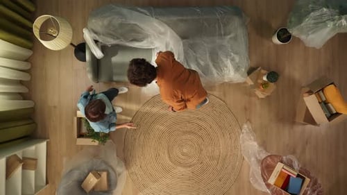 Top View Apartment Living Room Couple Standing in Room with Furniture and Boxes Looking Around
