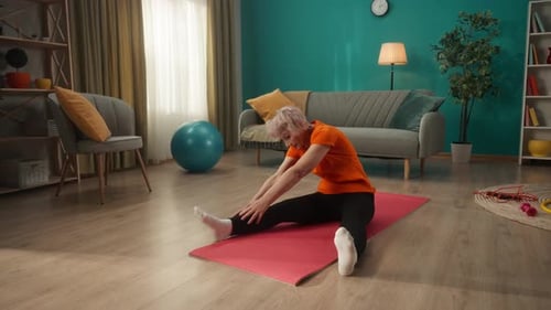 Senior Woman Stretching on Yoga Mat at Home