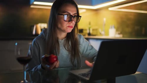 Woman Works on Laptop at Home at Night