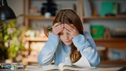 Tired Young Girl Struggling with Homework at Desk
