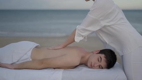 Young Caucasian Non Binary Person in Healing Massage at the Beach