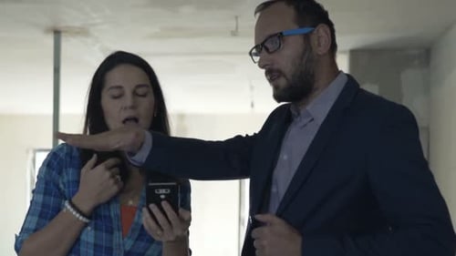 Businessman, Real Estate Agent with Smartphone Explaining to Client Project at New