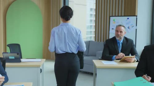 Woman Arrives at Desk in Modern Office