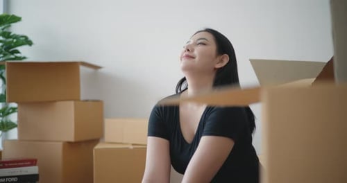 Woman Relaxes after Packing, Stretches in New Home