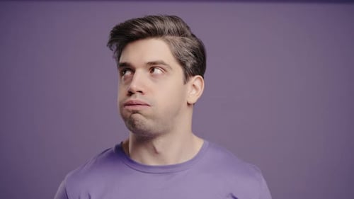 Man Rolls His Eyes in Disapproval on Purple Background