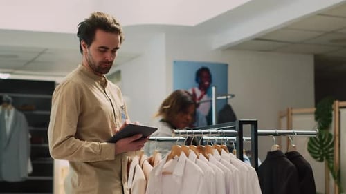 Boutique Employee Doing Inventory Near Store Aisles