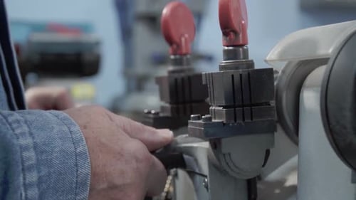 Close-up of Latin man's hands manipulating special industrial to duplicate lock keys. Mexico.