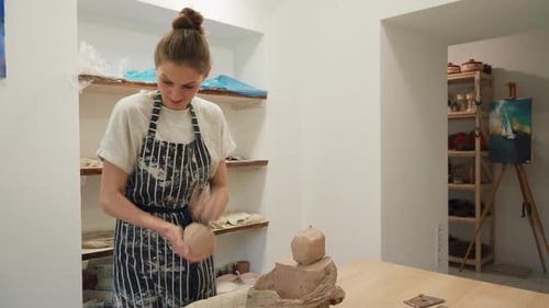 A charming woman potter prepares a piece of clay for further work. Close-up. Pottery workshop.