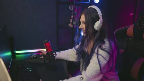 Happy Gamer Leans Forward Smiling After Winning Computer Game in Colorful Studio