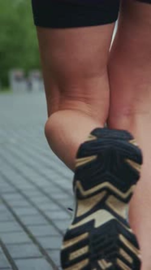 Woman Exercising Outdoors Running on Urban Sidewalk