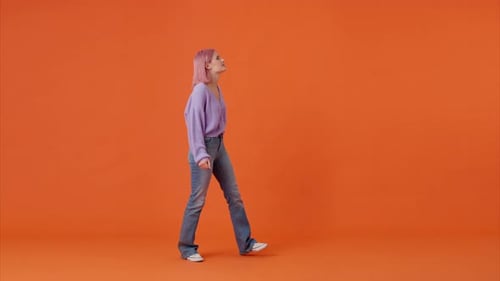 Woman Gesturing on Orange Studio Background