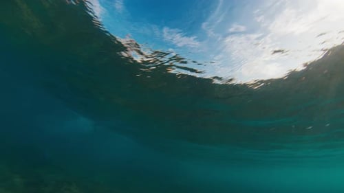 Underwater View of the Ocean Wave Breaking on the Shore During Sunset Light in the Maldives
