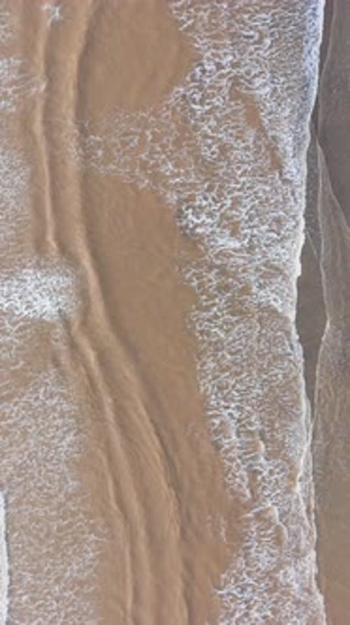 Waves wash over the beach shore in Tra Vinh, Vietnam, during the day.