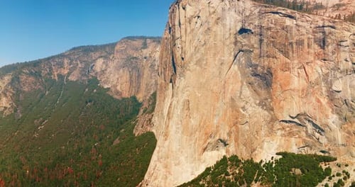 Enormes acantilados desnudos con pinos en la parte superior y al pie. Impresionantes rocas del parque de Yosemite