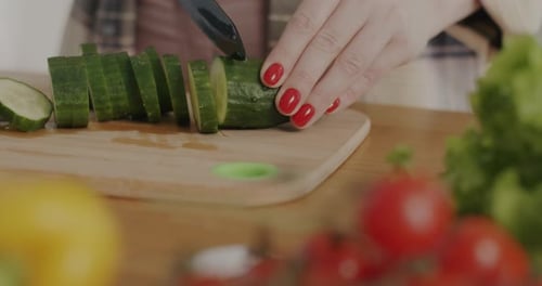 Slicing a cucumber on a Cutting Board
