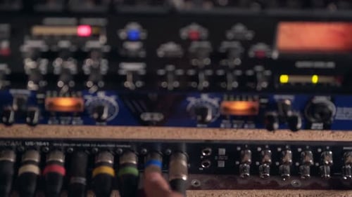 closeup, male hands connect microphone plug to instruments in studio