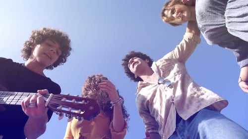 Friends Sing and Play Guitar in Sunlight