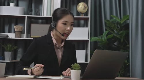 Woman Telecommuting With Laptop and Headset