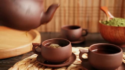 Cerimônia do chá: utensílio de chá asiático tradicional que serve um conjunto autêntico, pessoa servindo chá marrom