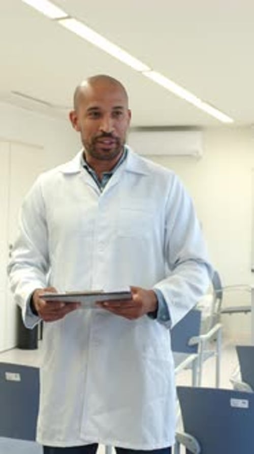 Man in Lab Coat Teaching in Classroom