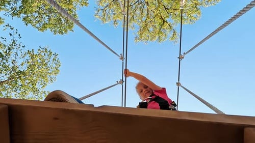 Happy Little Girl Playing in Tarzan Attraction on Playground in Amusement Park. Little Girls Enjoy P