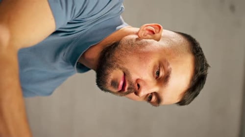 Vertical Video Closeup of a Young Artist in Blue Tshirt in an Art Studio Working on a Painting