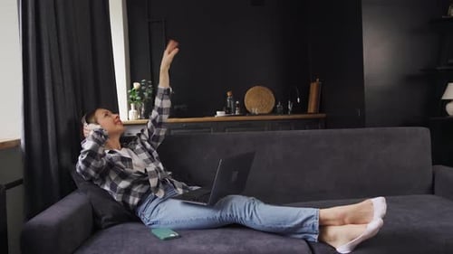 Woman Relaxing with Music on Couch