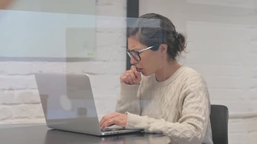 Hustende kreative Inderin tippt auf Laptop